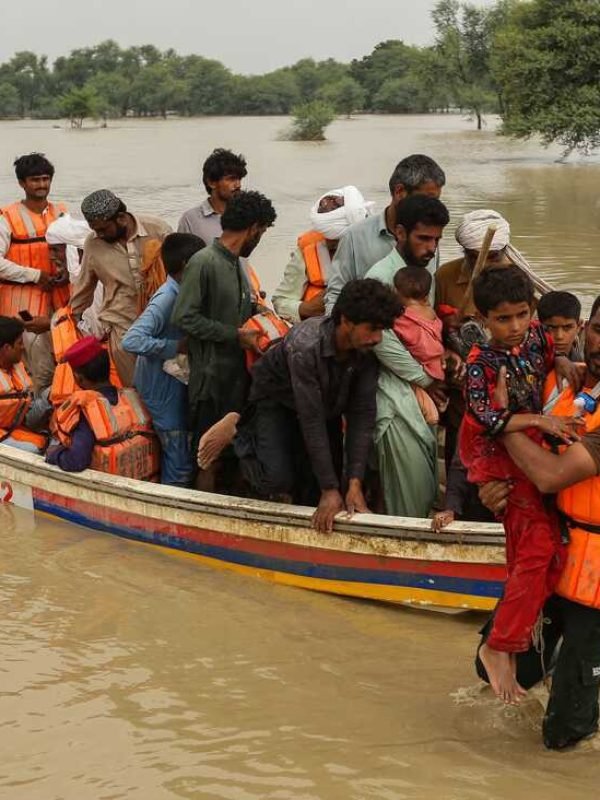 Rescue workers help evacuating flood affected people from their flood hit homes following heavy monsoon rains in Rajanpur district of Punjab province on August 27, 2022. - Heavy rain pounded much of Pakistan on August 26 after the government declared an emergency to deal with monsoon flooding it said had affected more than 30 million people. (Photo by Shahid Saeed MIRZA / AFP) (Photo by SHAHID SAEED MIRZA/AFP via Getty Images)